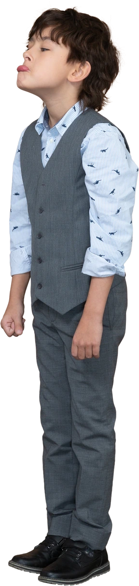 Side view of a cute boy in grey suit making faces