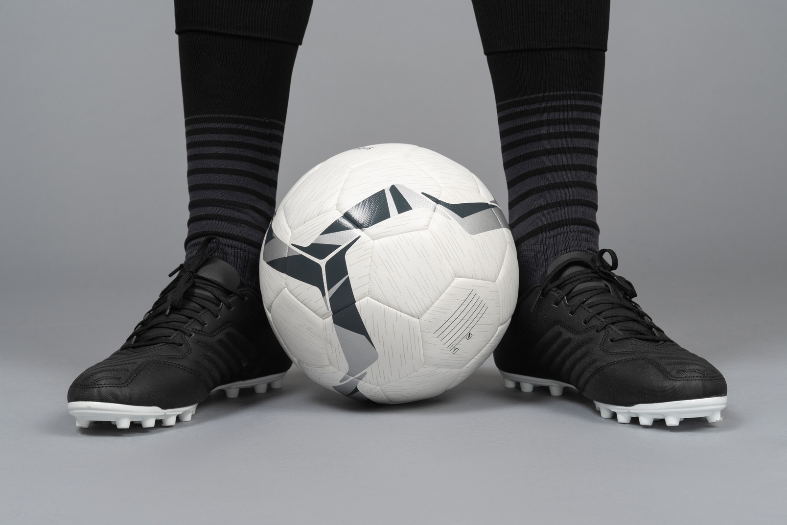 Close-up of a soccer player's legs holding a ball