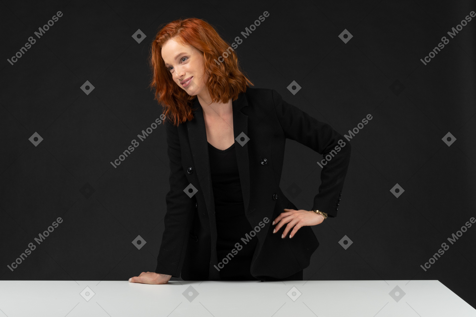 검은 옷을 입고 테이블에 서있는 아름다운 웃는 여자