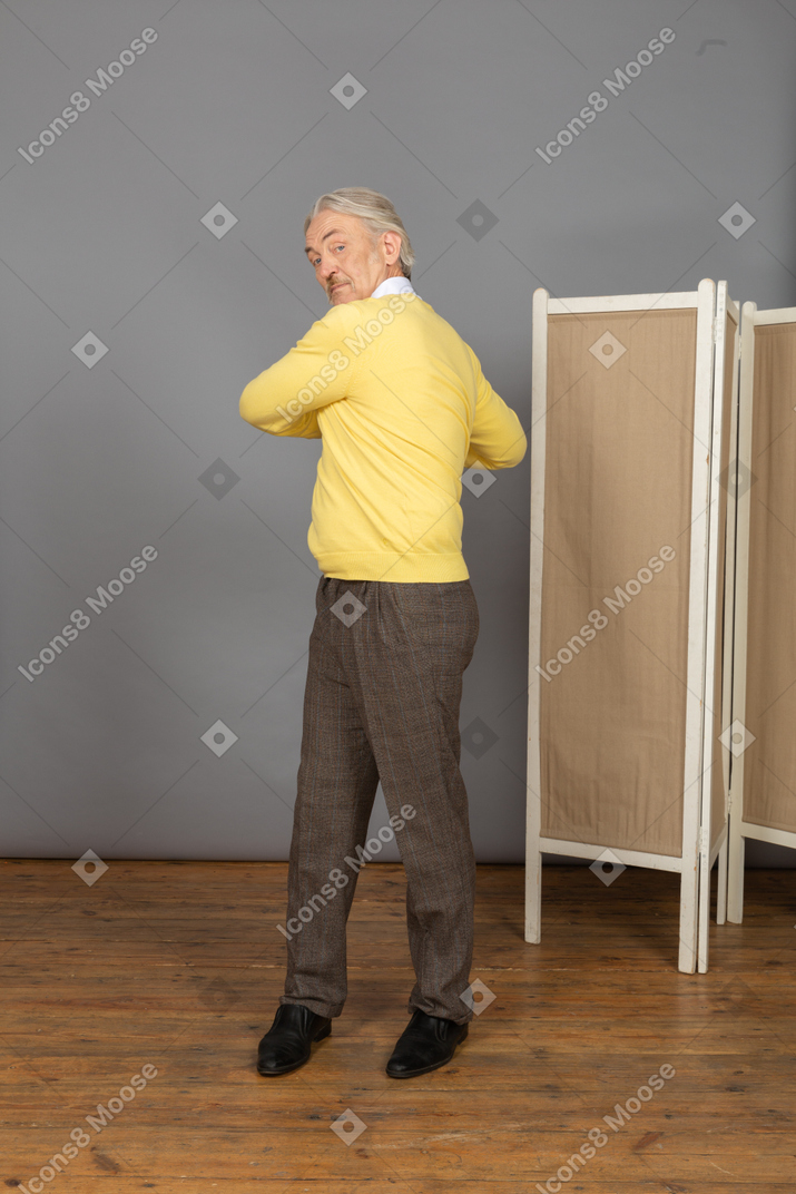 Front view of an old man exercising by making rotation