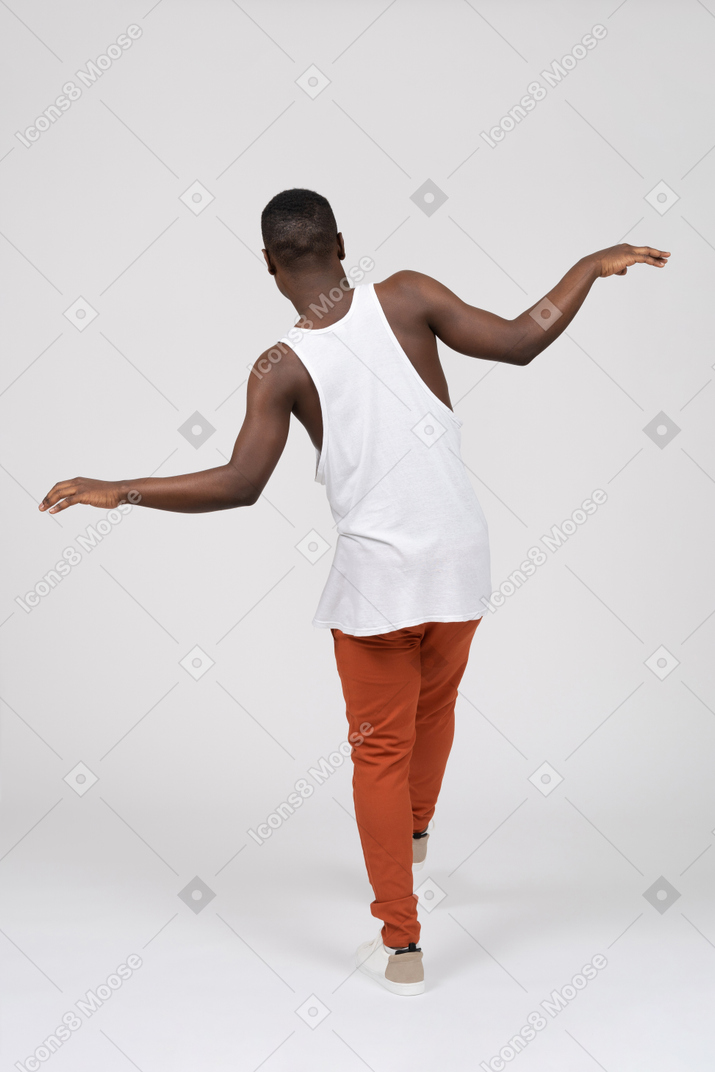 Back view of man balancing with spread hands