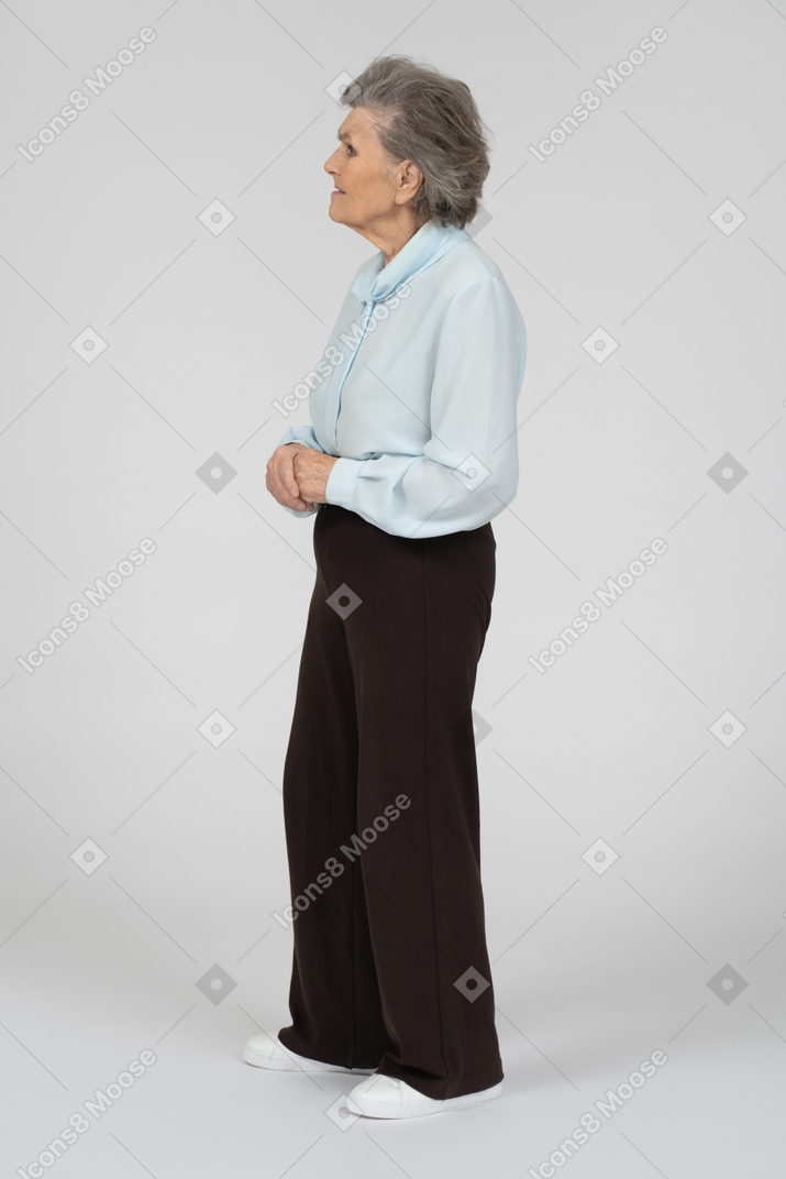 Вид сбоку на пожилую женщину со сложенными руками