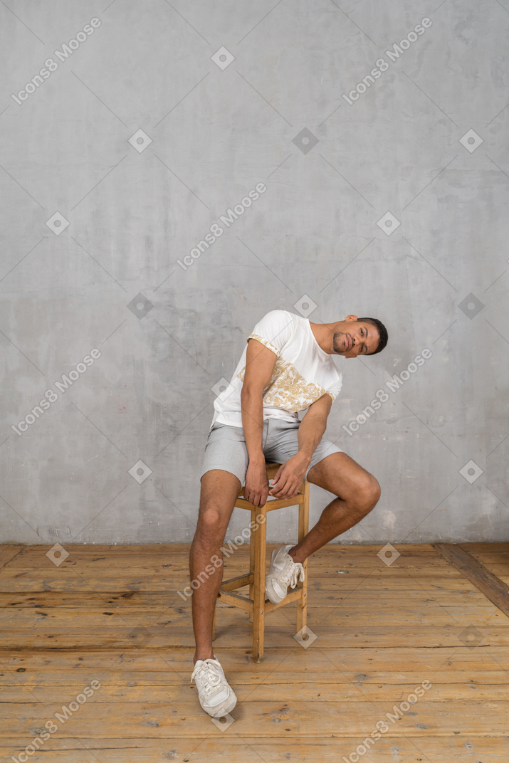Man sitting on chair and bending sideways