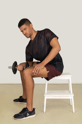 Young man in sports clothes lifting weights