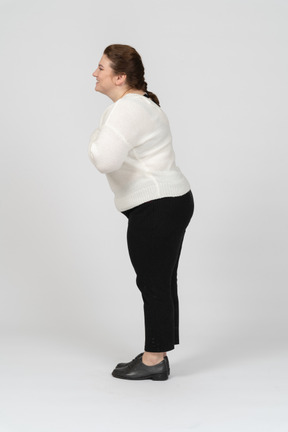 Vista laterale di una donna grassoccia felice in abiti casual