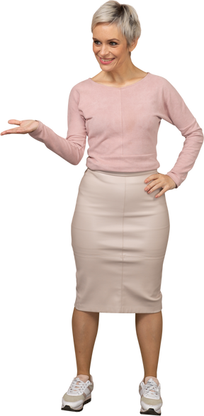 Vista frontal de uma mulher com roupas casuais em pé com a mão estendida