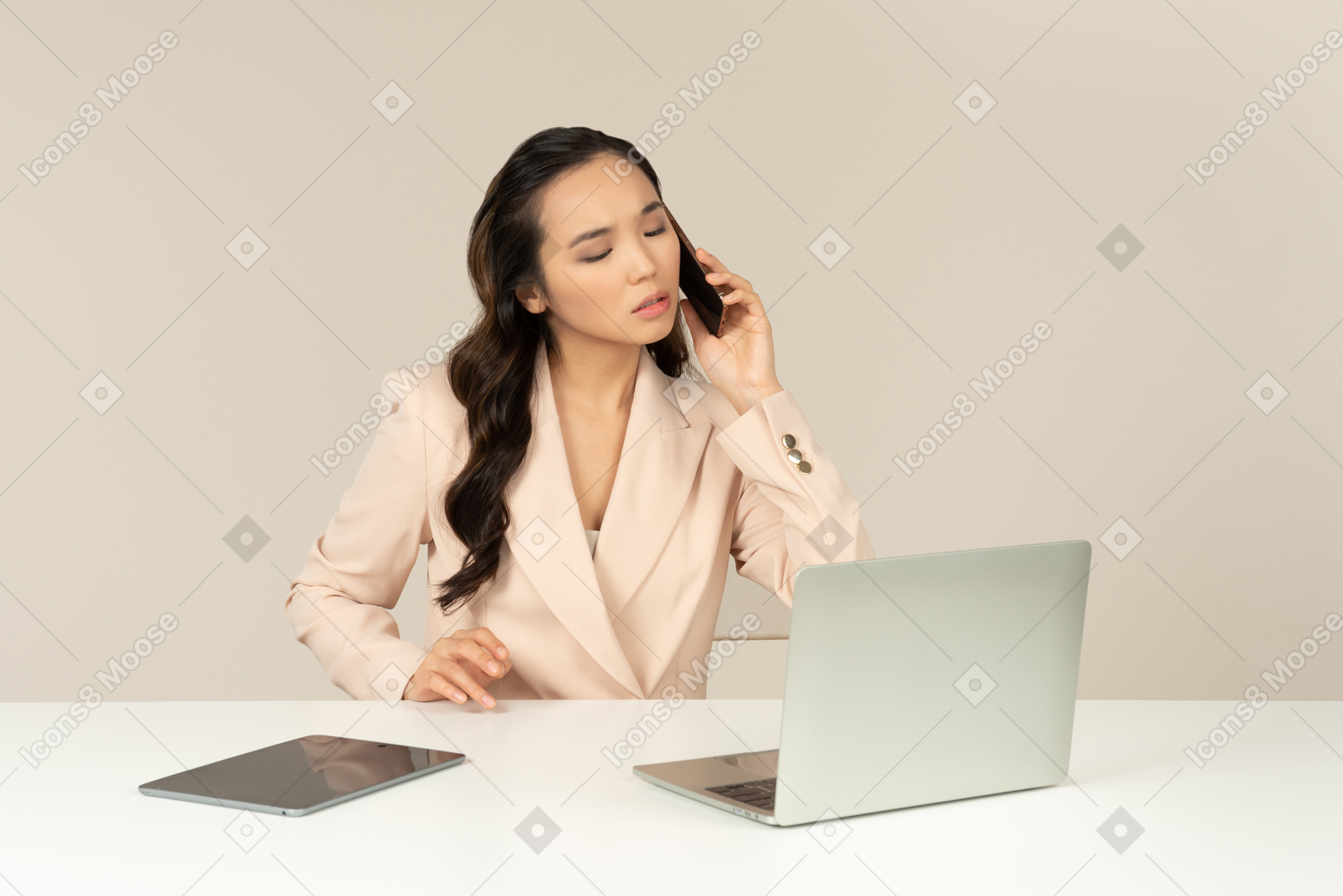 Bothered asian office employee talking on the phone