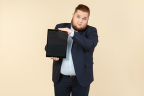 Young overweight man holding digital tablet vertically