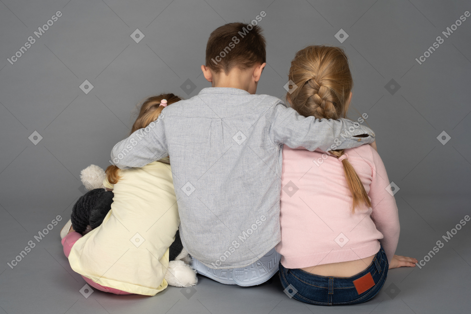 Menino abraçando duas meninas de volta para a câmera