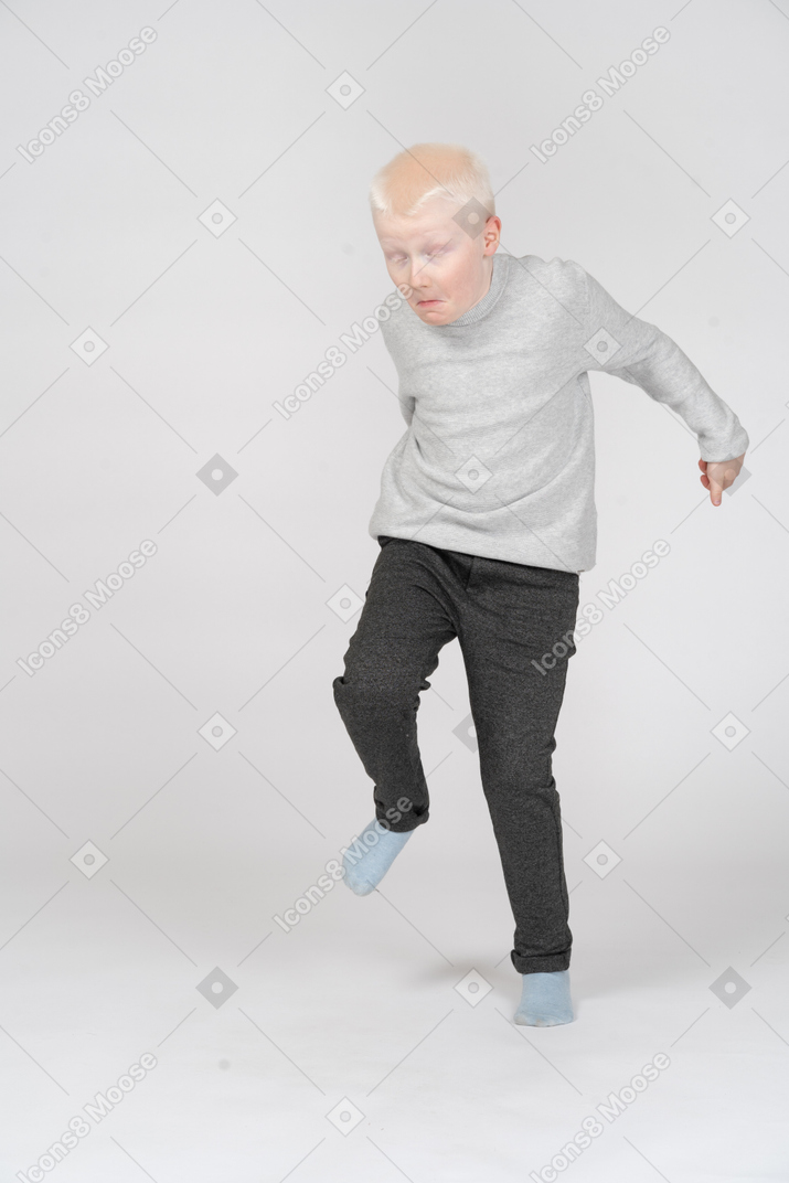 Front view of a boy jumping on one leg