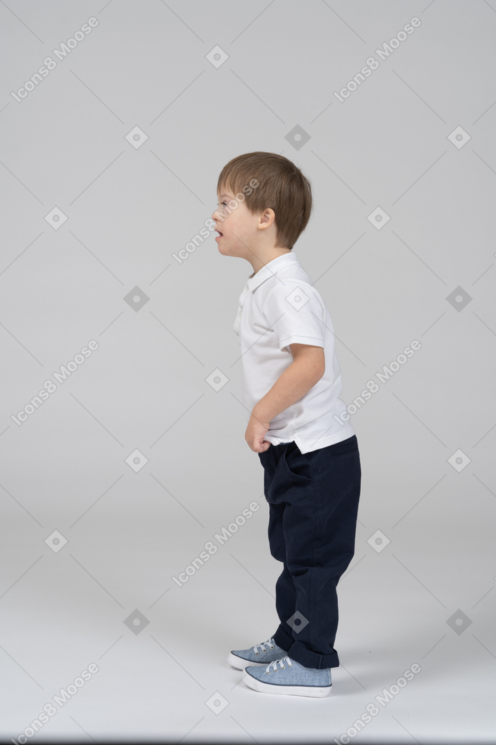Vista lateral de um menino surpreso, inclinando-se para a frente