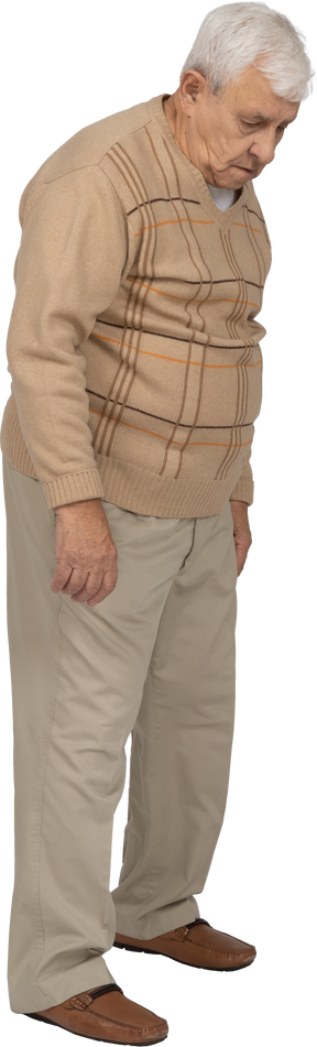 Vista lateral de un anciano con ropa informal mirando hacia abajo