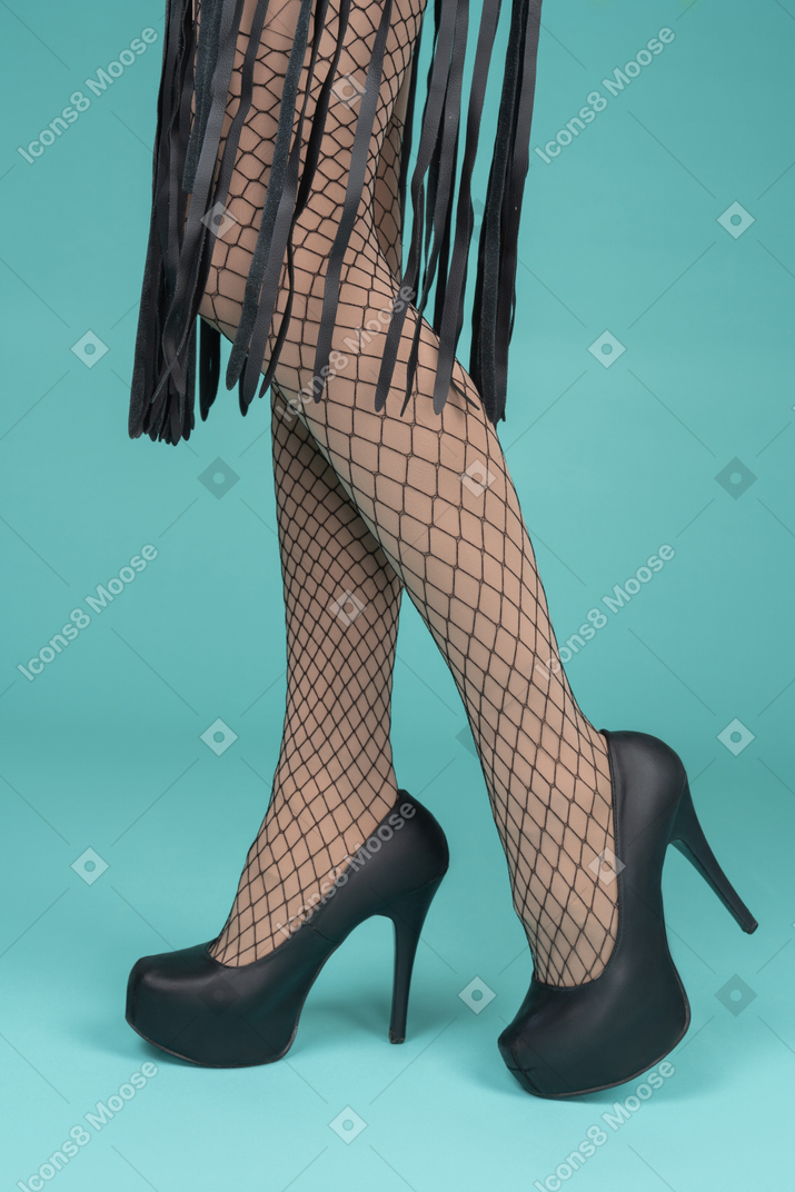 Side view of legs in fishnets and high heels