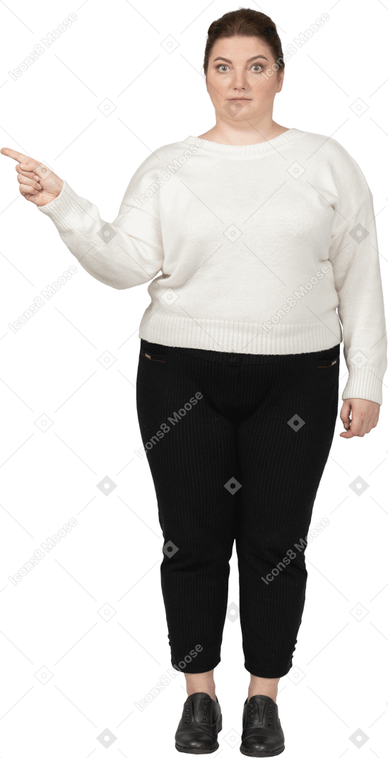 指で指している白いセーターのプラスサイズの女性