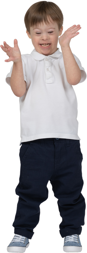 Front view of a boy smiling and gesturing excitedly with his hands