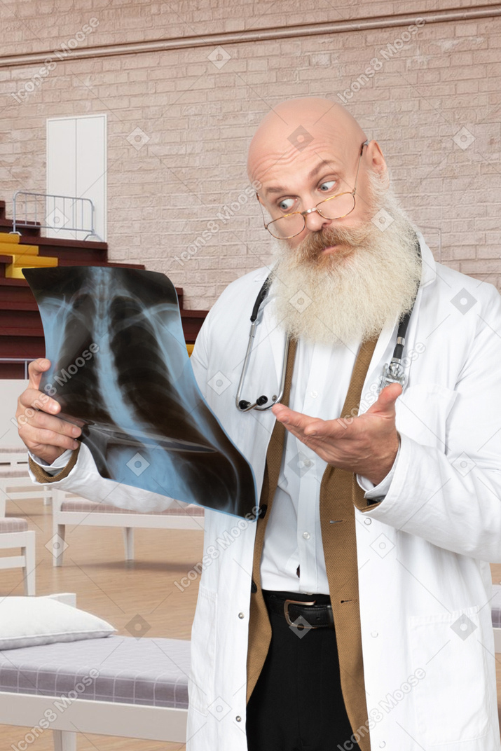 A man in a lab coat holding a x - ray