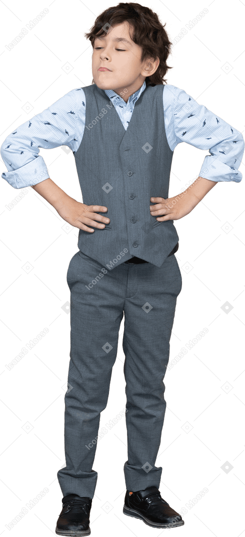 Front view of a cute boy in suit posing with hands on hips