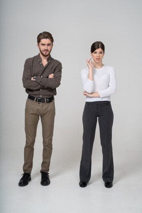 Front view of an arrogant man and questioning woman in office clothing