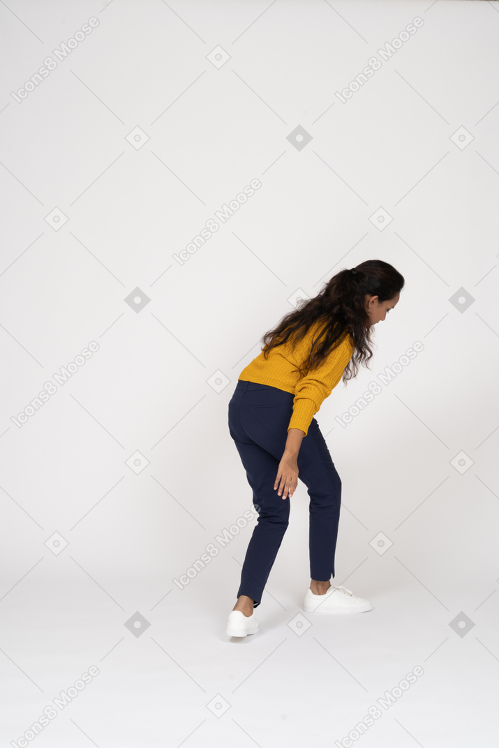 Vista posteriore di una ragazza in abiti casual che cammina