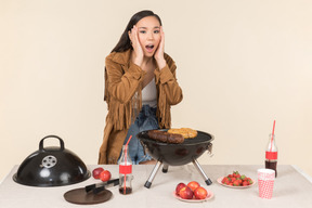 Young asian girl having problem with barbecue