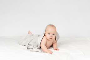 灰色のタオルで覆われている女の赤ちゃん