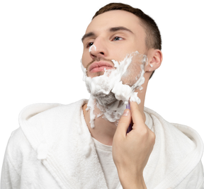 Portrait of a young caucasian man being shaved
