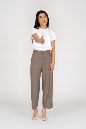 Vista frontal de un saludo señorita en calzones y camiseta extendiendo su mano
