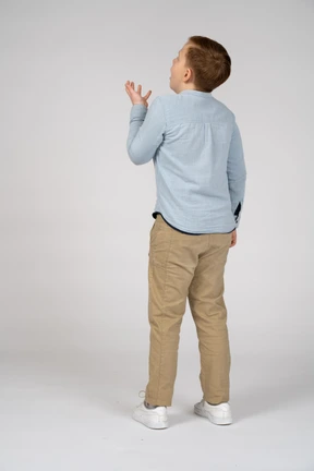 Emotional boy standing back to camera and gesturing