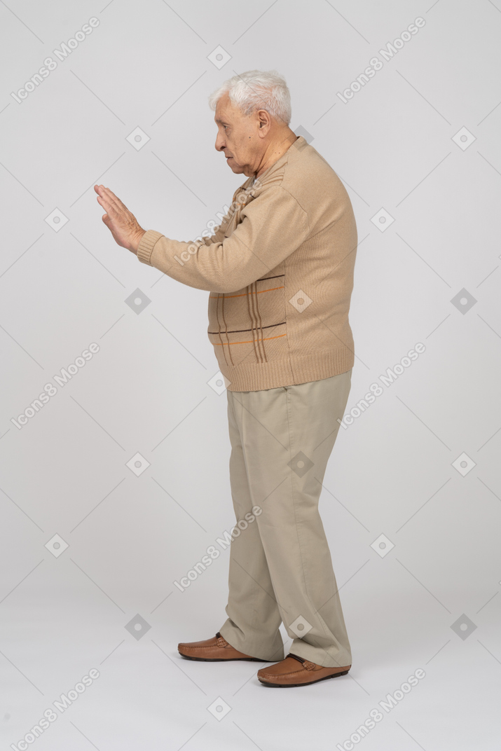 一位穿着休闲服的老人的侧视图显示停止手势