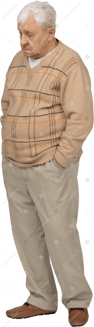 ポケットに手を入れて立っているカジュアルな服を着て、興味のあるものを見ている老人の正面図