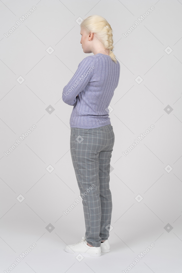 Back view of young woman with crossed arms