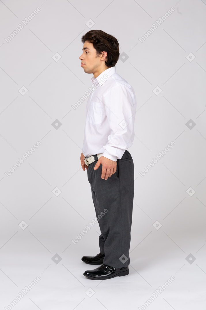 Vista laterale di un giovane uomo in abbigliamento formale che guarda lontano