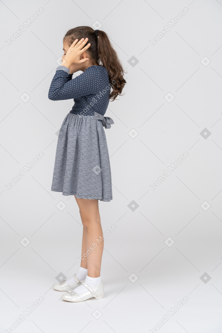 Vista laterale di una ragazza che copre le orecchie con le mani