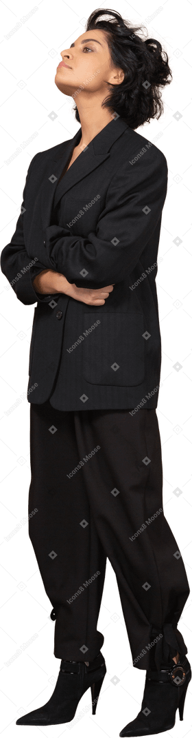 Vista de tres cuartos de una empresaria vestida con traje negro cruzando las manos y echando la cabeza hacia atrás