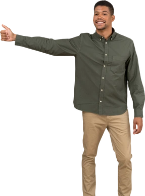Front view of a smiling man hitchhiking