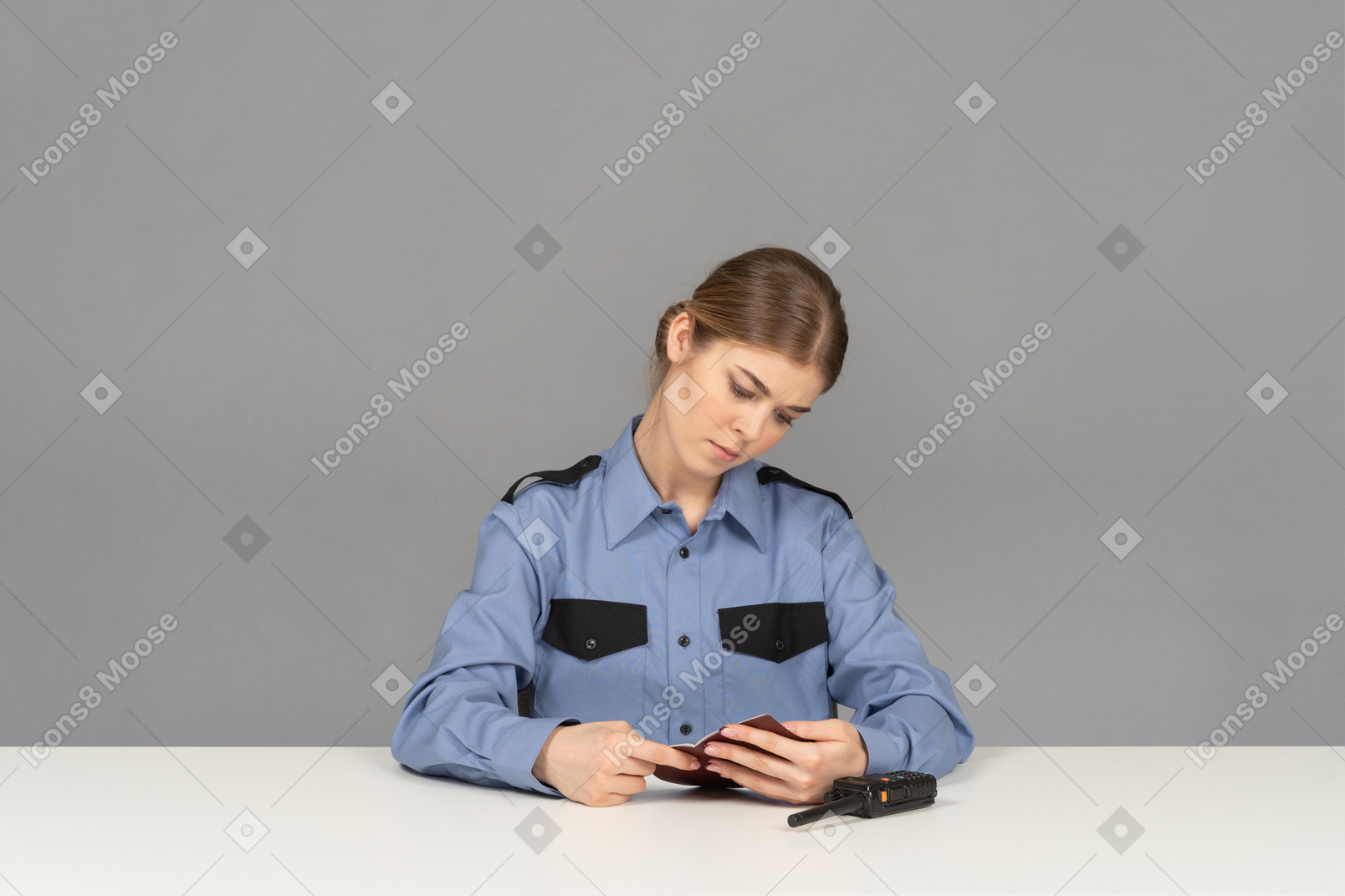 A young female security guard using a mobile phone