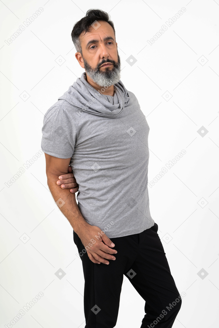 Involved in thoughts mature man holding his one hand behind his back