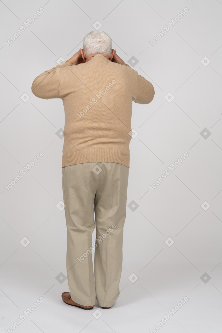 Retrovisione di un uomo anziano in abiti casual che copre gli occhi con le mani