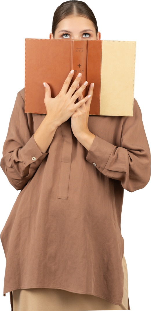 Woman covering her face with a book and looking up