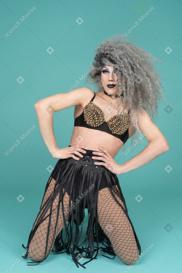 Drag queen standing on knees with hands on waist