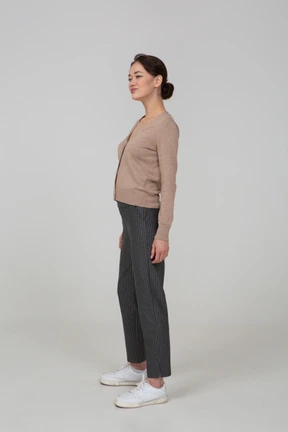 Three-quarter view of a suspicious young lady in pullover and pants
