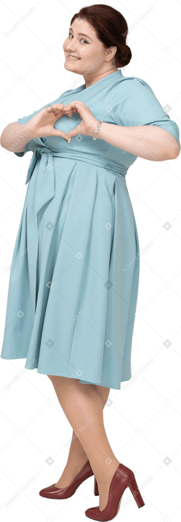 ハートのジェスチャーを示す青いドレスを着た女性の側面図