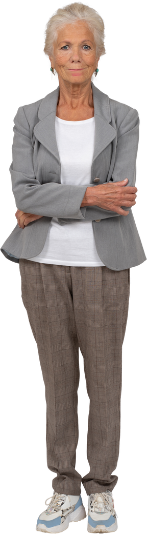 Vista frontal de uma senhora idosa de terno posando com os braços cruzados e olhando para a câmera