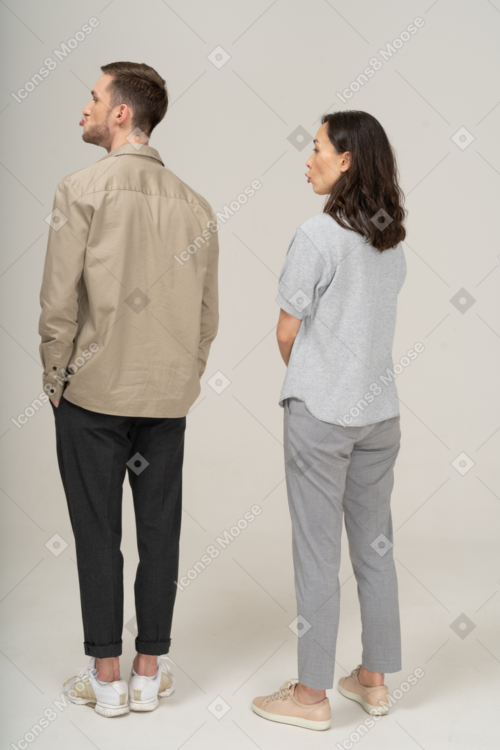 Three-quarter back view of young couple pouting