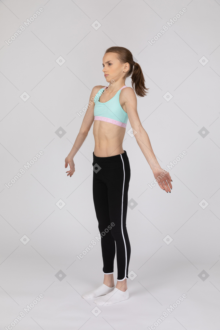 Una adolescente confundida de pie con los brazos extendidos.