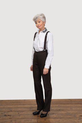 Vue de trois quarts d'une vieille femme perplexe en tenue de bureau