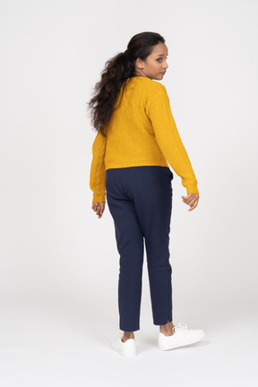 Rear view of a girl in casual clothes looking at something