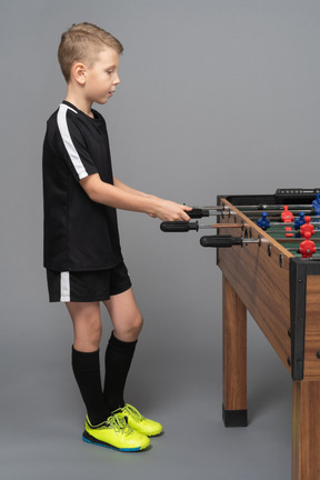 Side view of a boy playing foosball