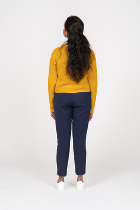 Rear view of a girl in casual clothes looking up