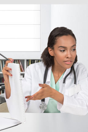 A doctor pointing at notepad